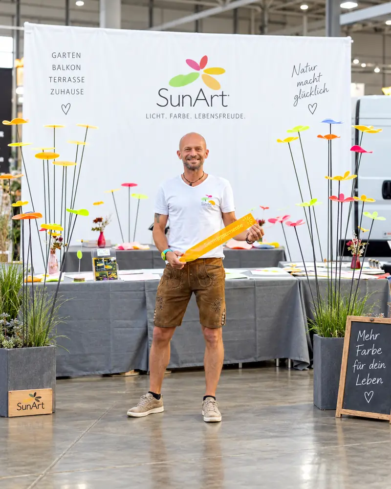 Sven am SunArt Messestand mit bunten Sonnenfängern